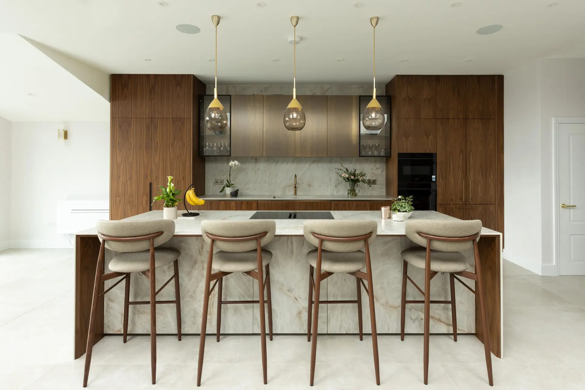 Bespoke kitchen in Winchmore Hill featuring walnut cabinetry and a statement Atlas Plan porcelain island