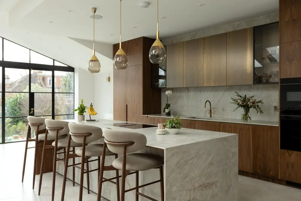 Bespoke kitchen in Winchmore Hill featuring walnut cabinetry and a statement Atlas Plan porcelain island