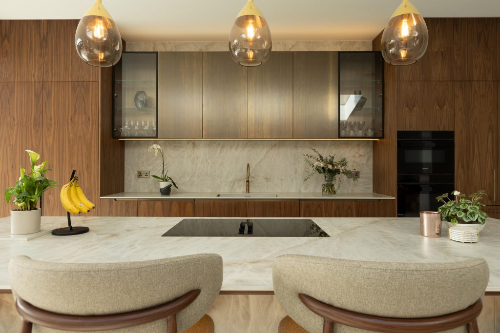 Luxury bespoke walnut kitchen with an Atlas Plan porcelain island, integrated lighting and Liquid Metal Doors