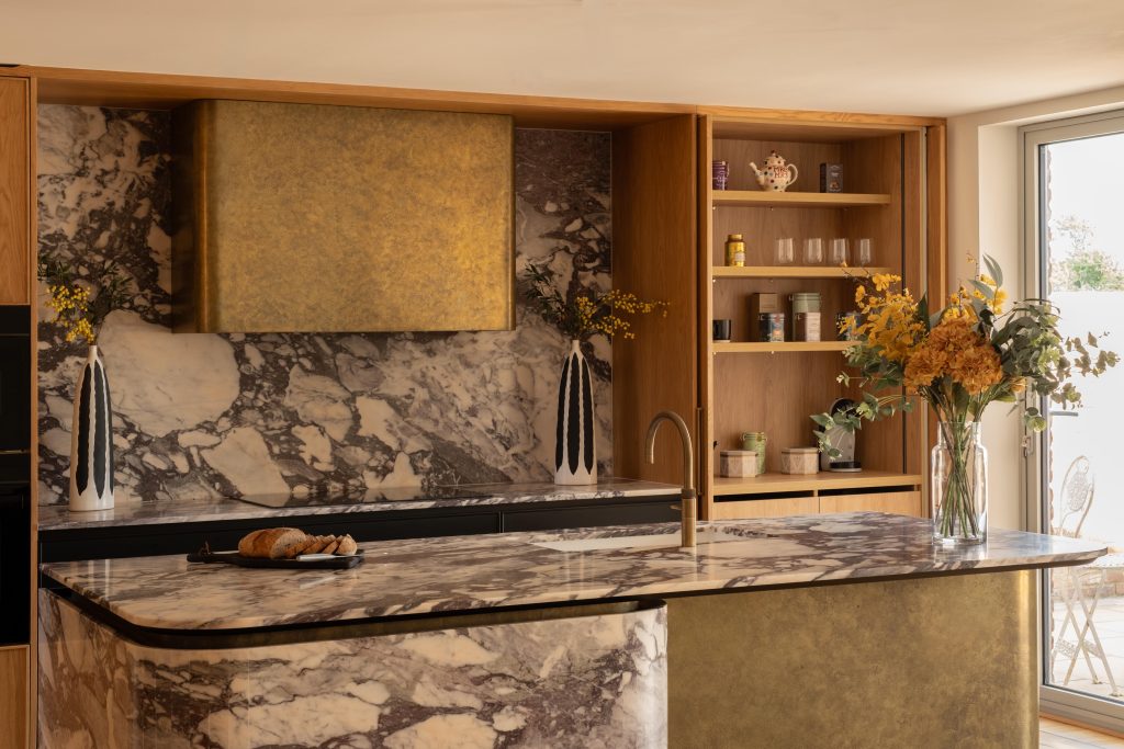 Sculptural floating Viola marble kitchen island with curved stone detailing and Liquid Metal Gold Finishes